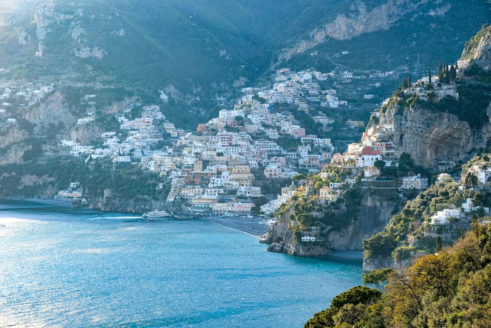 Stunning aerial view of the Amalfi Coast with colorful hillside buildings and turquoise sea.
